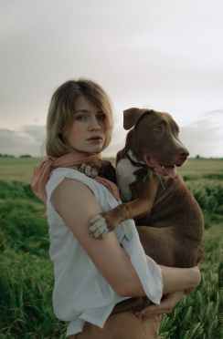 woman carrying a dog on her arms
